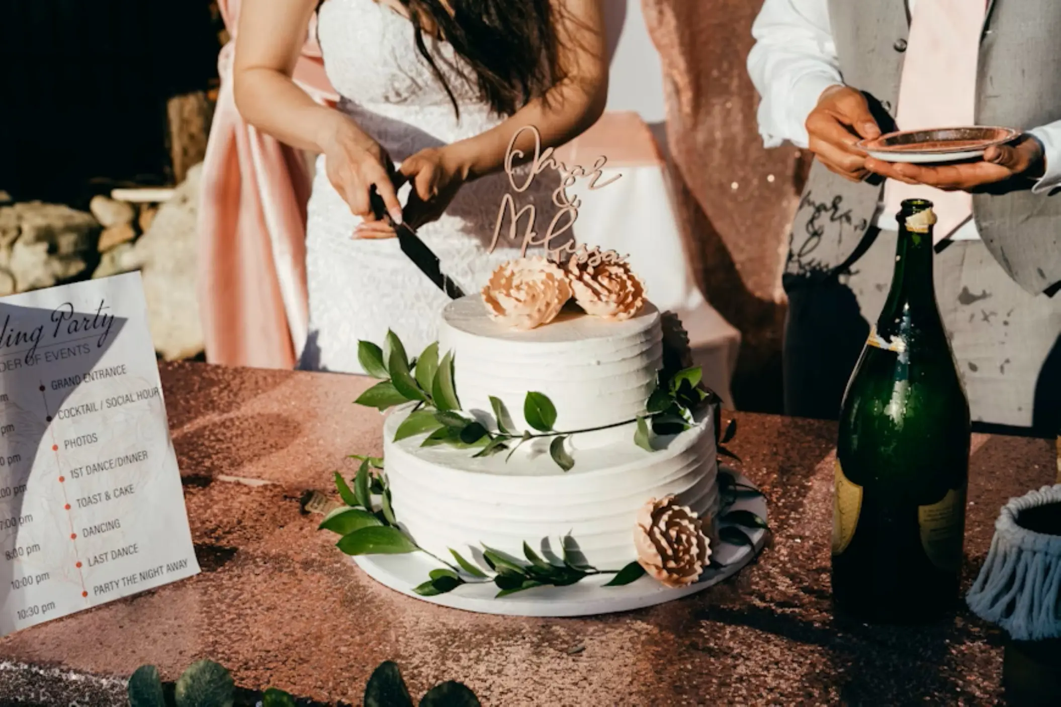 The bride and groom cutting a two-tier white wedding cake at Secrets Mirabel, Cancun