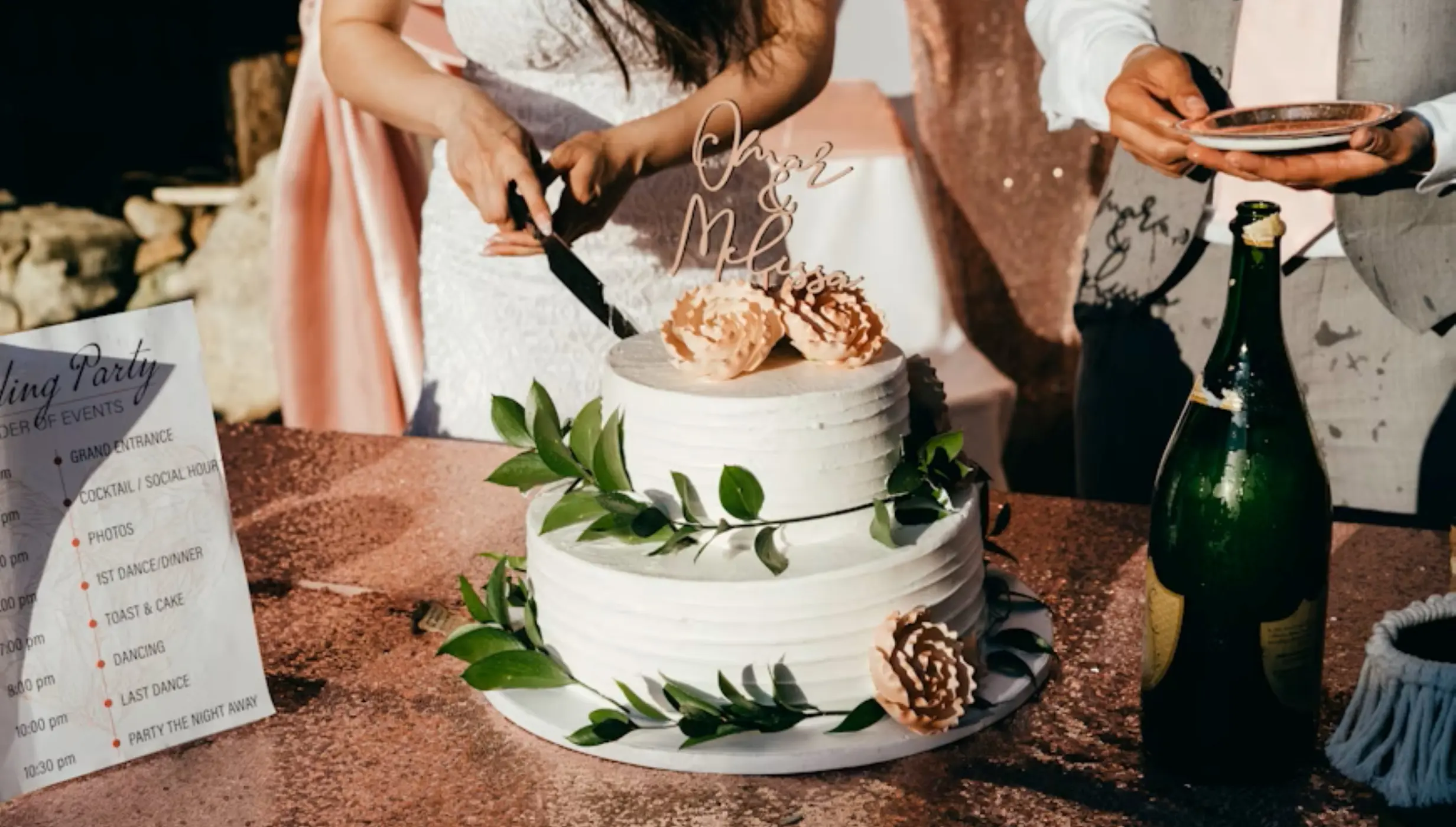 The bride and groom cutting a two-tier white wedding cake at Secrets Mirabel, Cancun