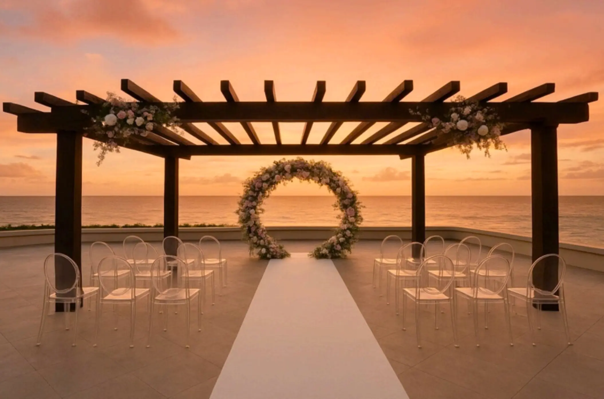 Oceanfront terrace wedding ceremony setup with floral arch at sunset, Secrets Mirabel Cancun