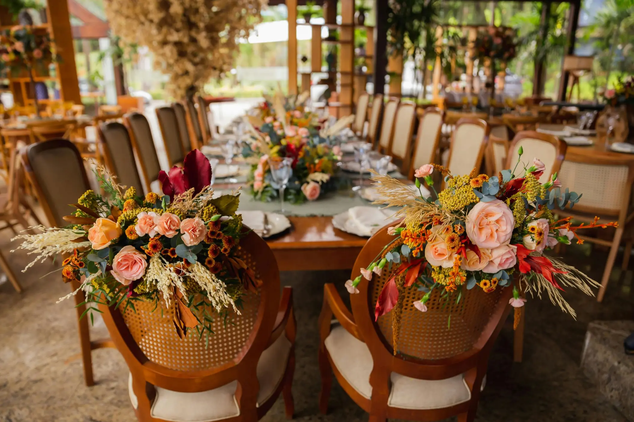 Floral arrangements on wooden chairs at a Secrets Mirabel Cancun wedding reception, Cancun