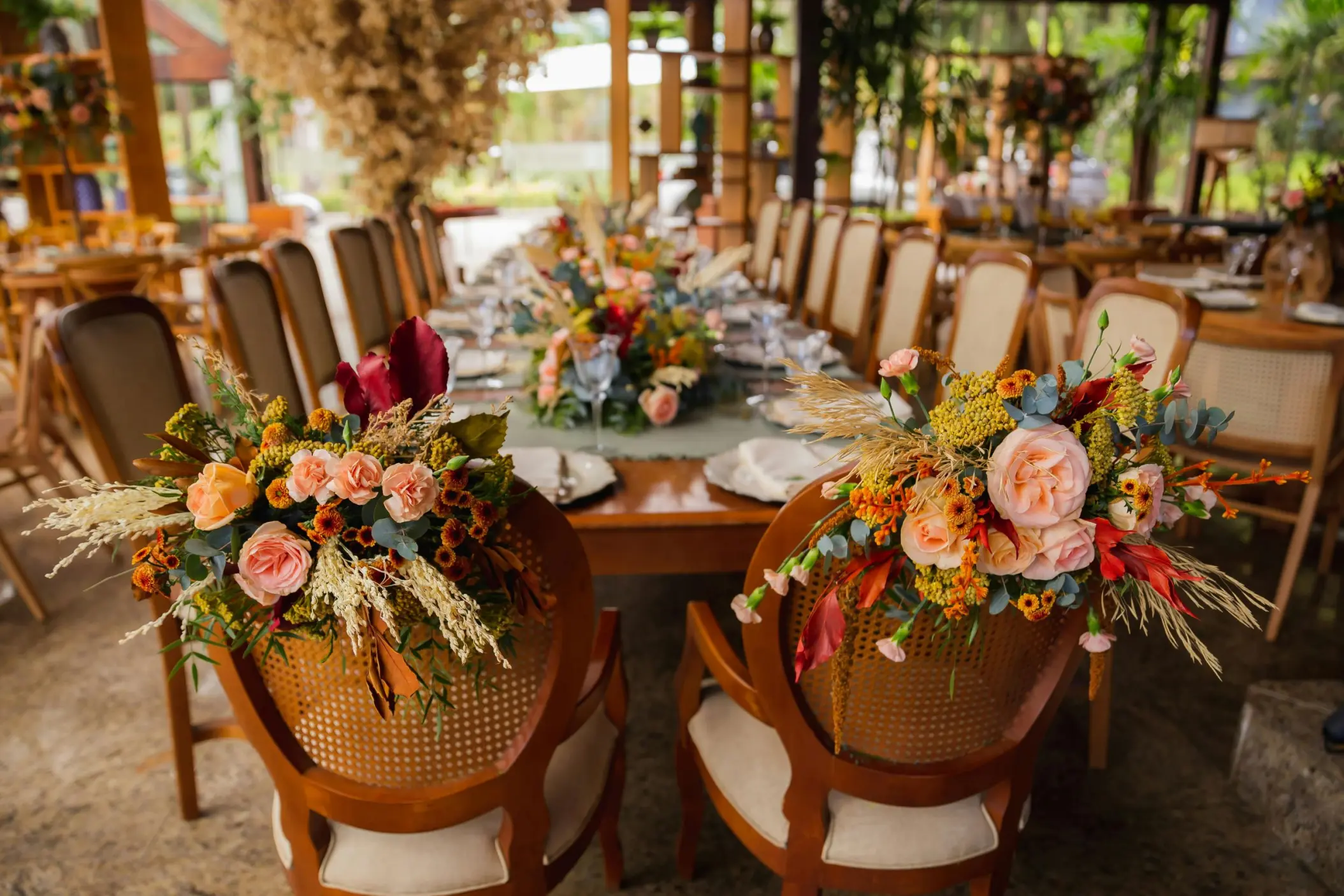 Floral arrangements on wooden chairs at a Secrets Mirabel Cancun wedding reception, Cancun