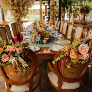 Floral arrangements on wooden chairs at a Secrets Mirabel Cancun wedding reception, Cancun