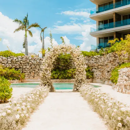 Floral ceremony arch by a cenote-style pool at Secrets Moxche, Playa Del Carmen