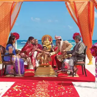 South Asian wedding ceremony under an orange mandap at Secrets Moxche, Playa Del Carmen