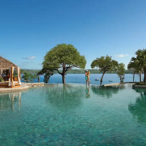 Couple standing by the infinity pool at Secrets Papagayo, Papagayo