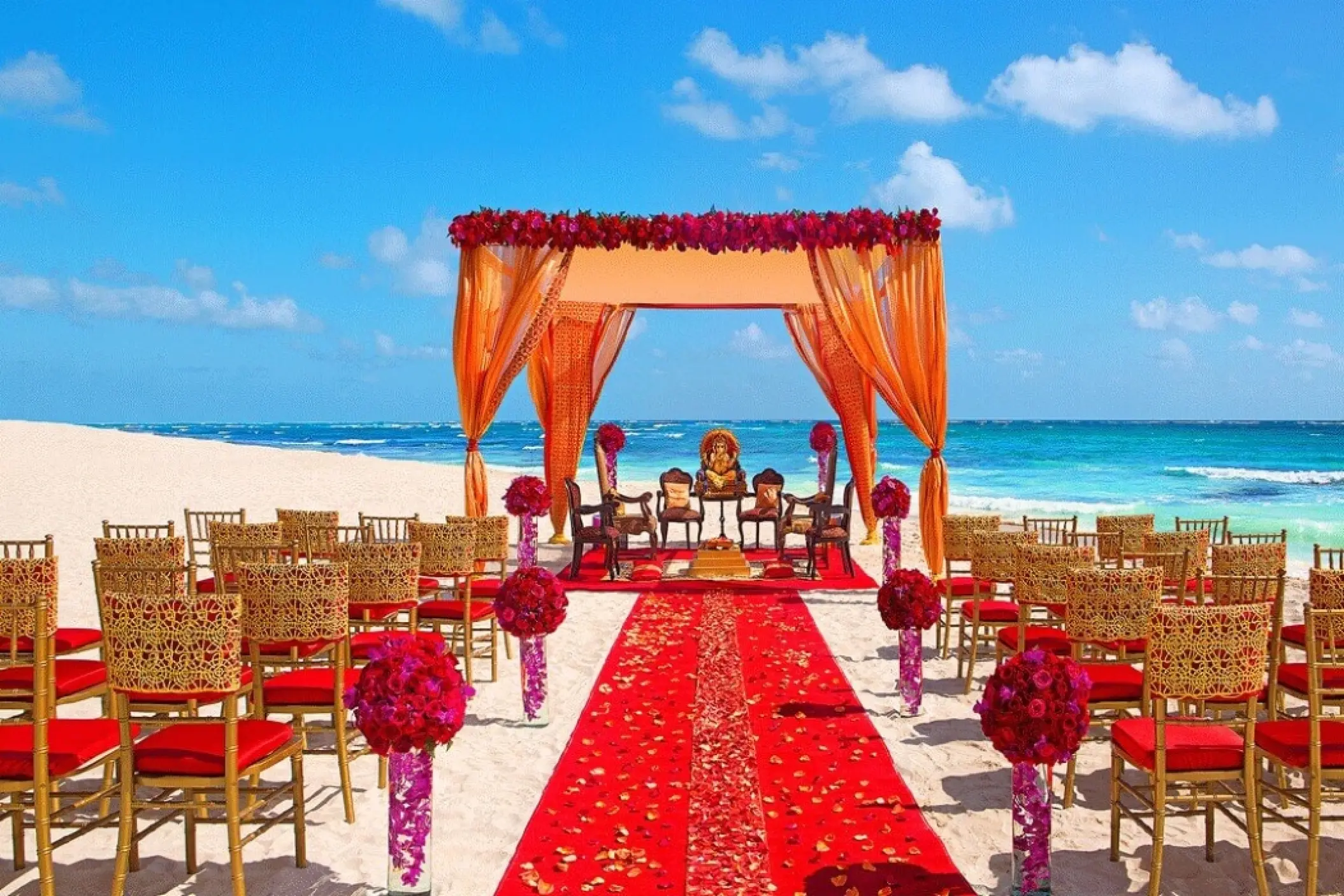 South Asian beach wedding ceremony with orange mandap and red aisle at Secrets Papagayo, Costa Rica