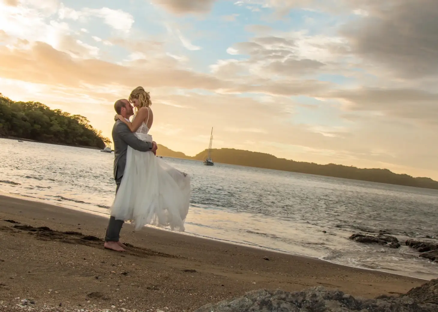 Groom lifting bride on the beach at sunset during a wedding at Secrets Papagayo, Papagayo