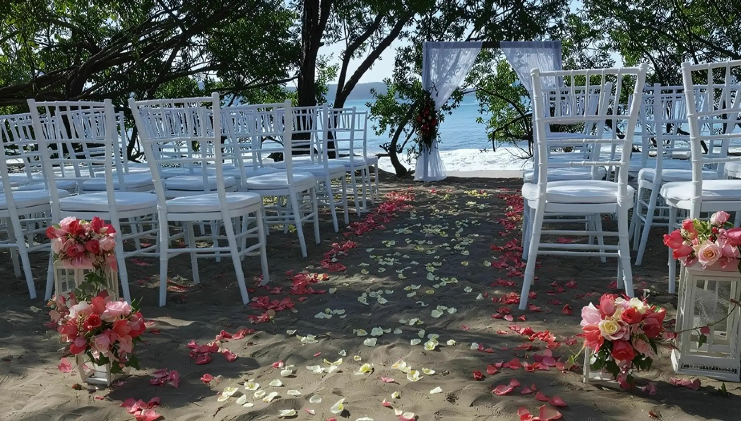Beachfront wedding ceremony with white chairs and floral petal aisle at Secrets Papagayo, Papagayo
