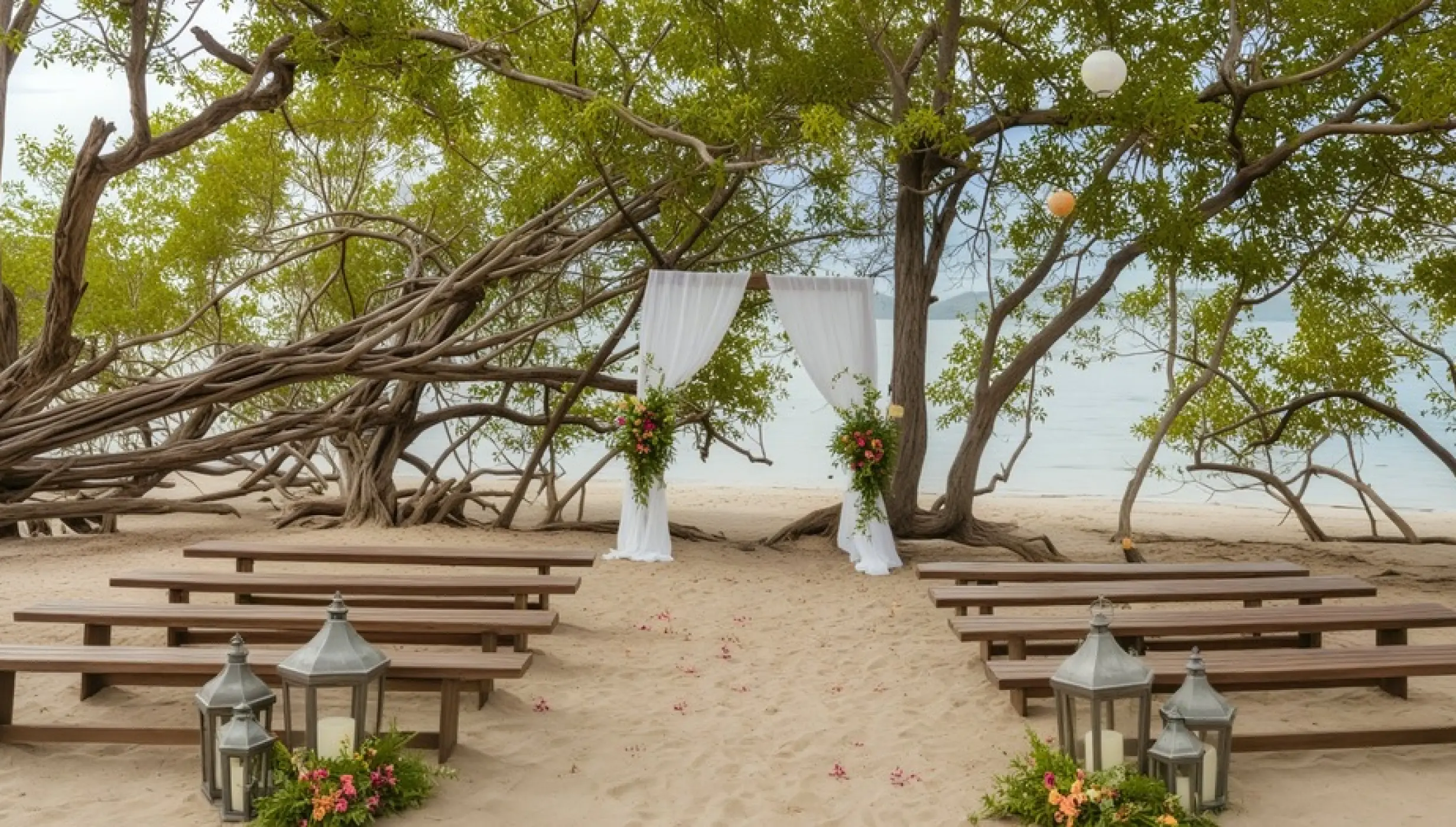 Beachfront wedding ceremony with wooden benches and white draped arch at Secrets Papagayo, Papagayo