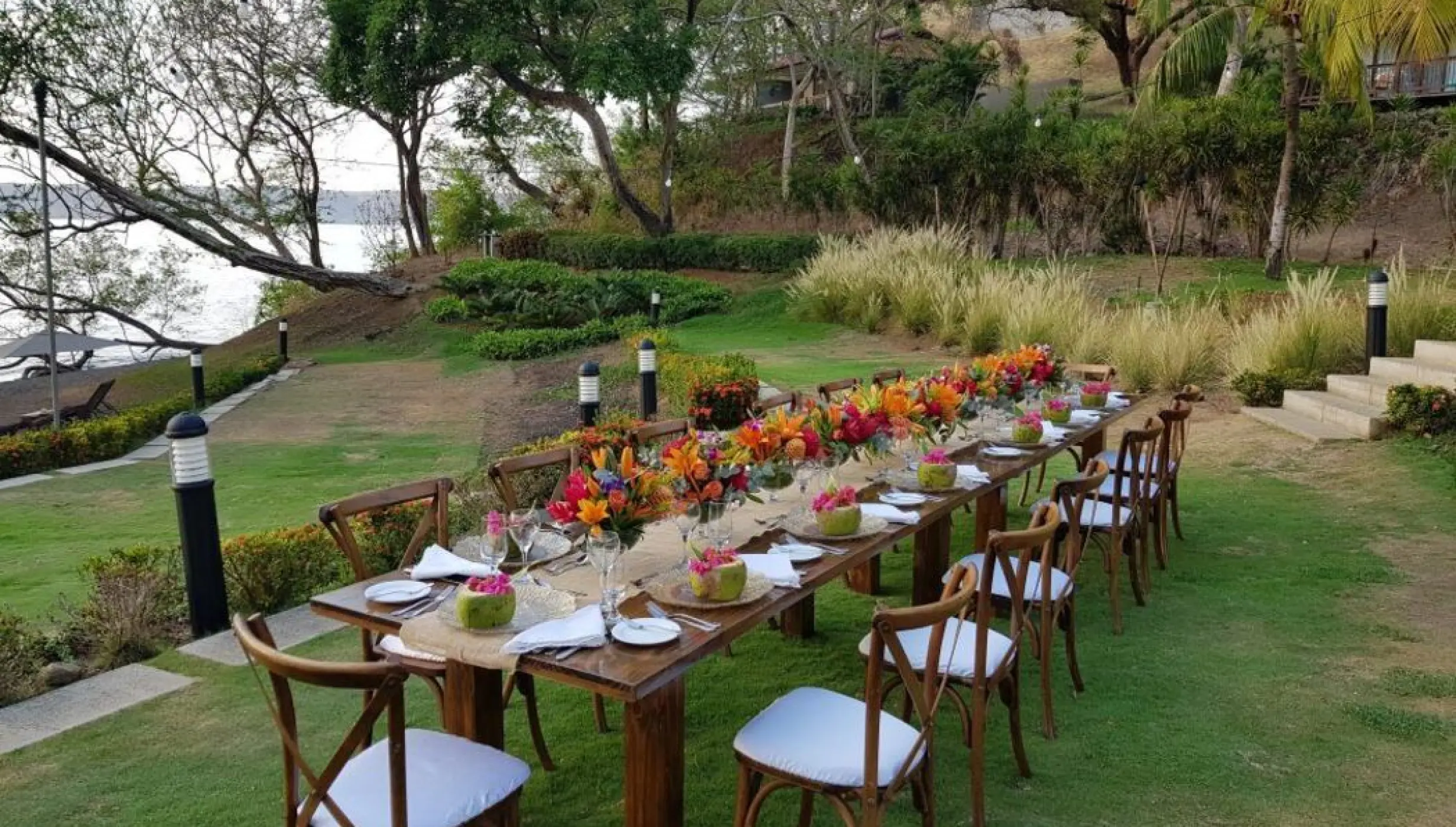 Long wooden banquet table with tropical flowers for a wedding reception at Secrets Papagayo, Papagayo