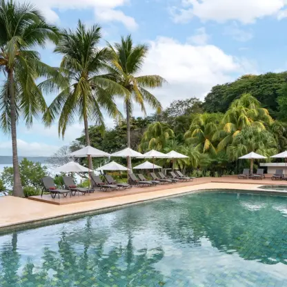Spa pool and lounge chairs under umbrellas at Secrets Papagayo, Papagayo