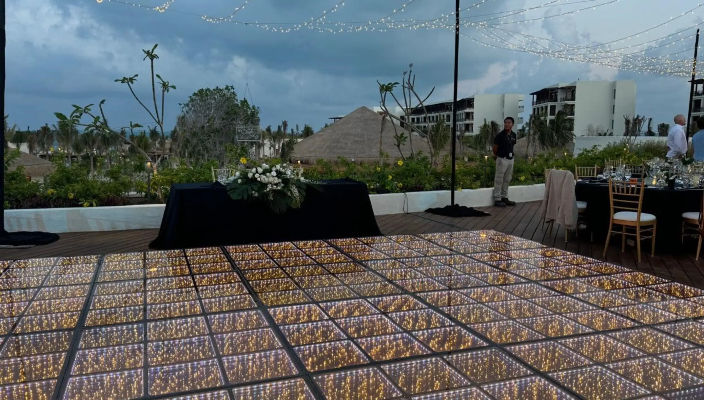 Illuminated dance floor and fairy lights for a rooftop wedding reception at Secrets Playa Blanca, Cancun
