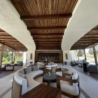 Preferred Club terrace lounge with modern seating under a wood-beamed ceiling at Secrets Playa Blanca, Cancun