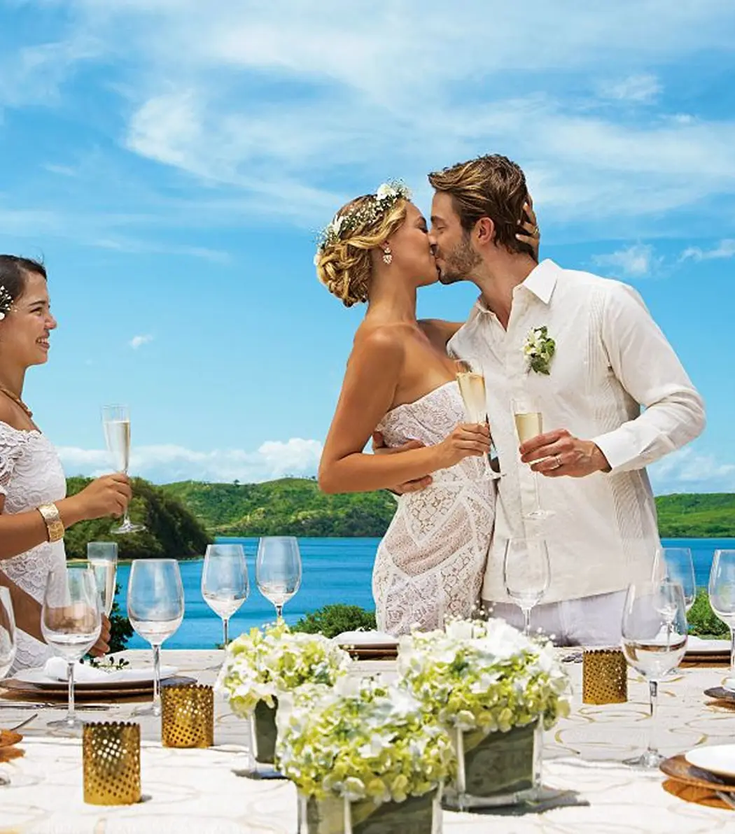 Bride and groom kissing at an outdoor wedding reception at Secrets Playa Esmeralda, Miches