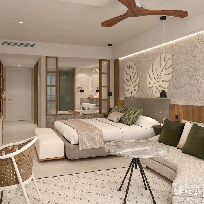 A junior suite with a king-sized bed, a sofa, a ceiling fan, and modern tropical decor.
