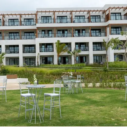 The Secrets Garden Lobby venue, a grassy lawn with cocktail tables in front of a hotel building.