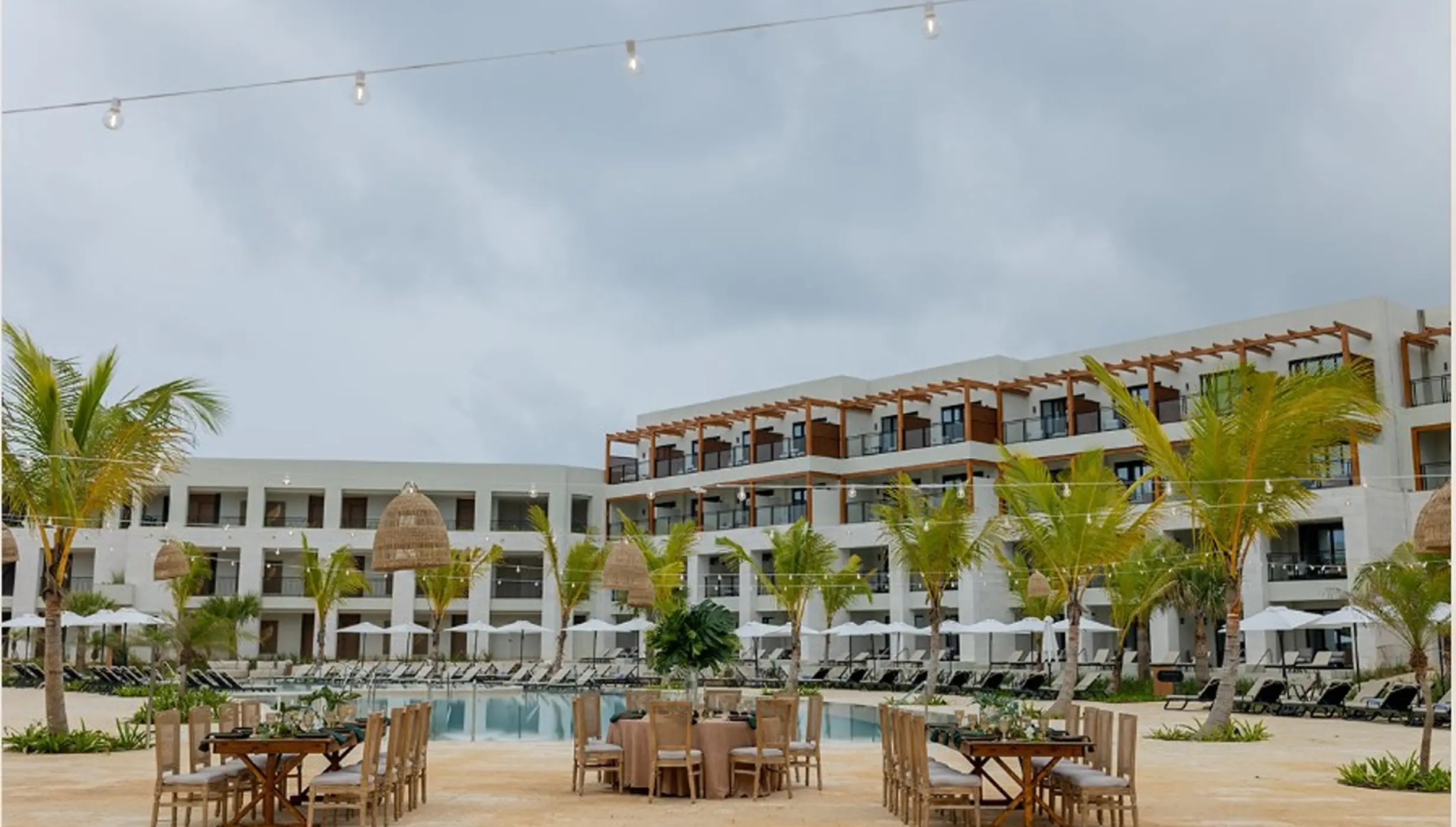 Poolside wedding reception setup with string lights at Secrets Playa Esmeralda, Miches