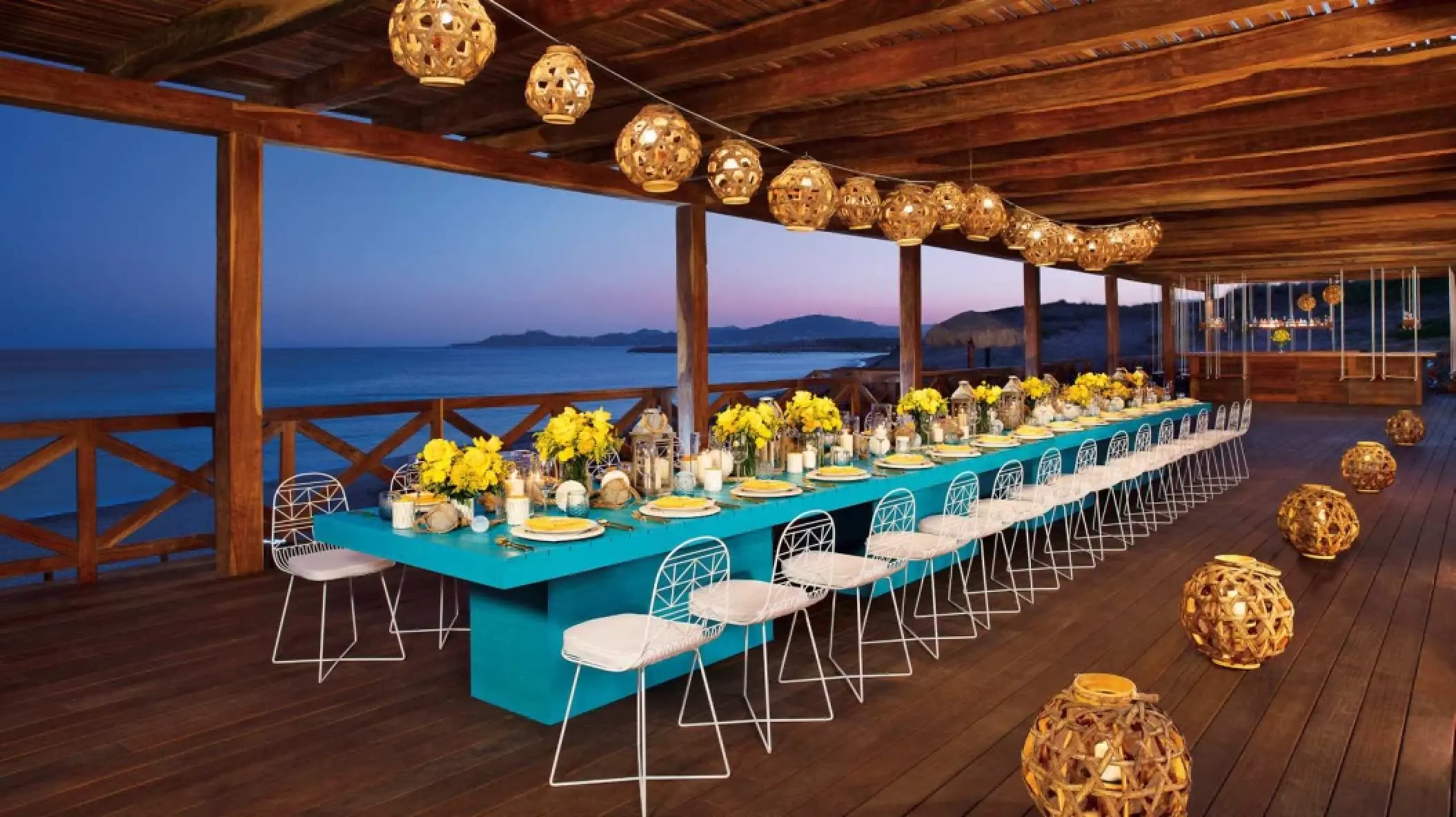 Terrace wedding reception with turquoise tables and yellow flowers at Secrets Puerto Los Cabos, Cabo San Lucas