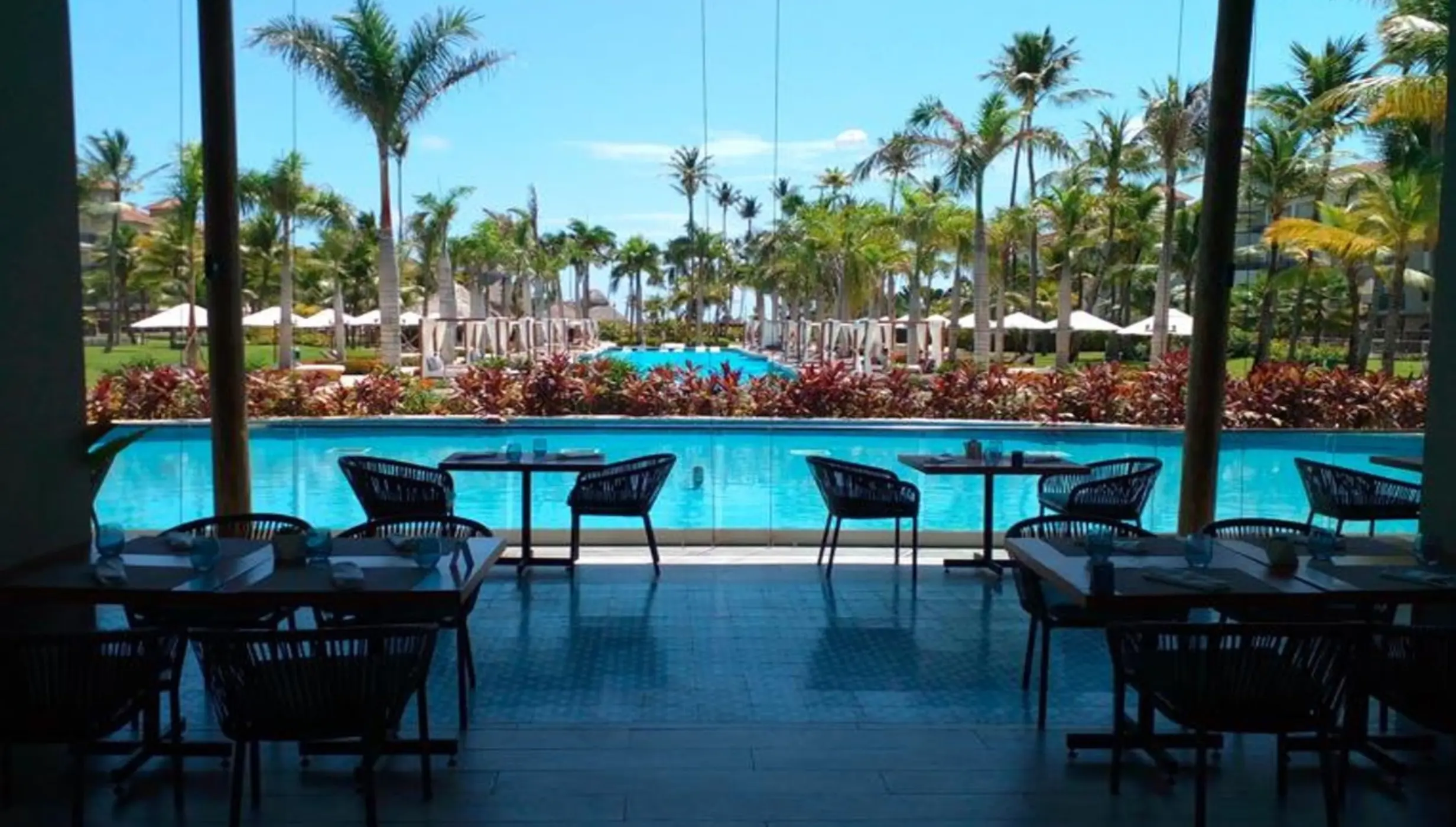 Riviera Terrace restaurant overlooking the swimming pools and palm trees at Secrets Royal Beach, Punta Cana