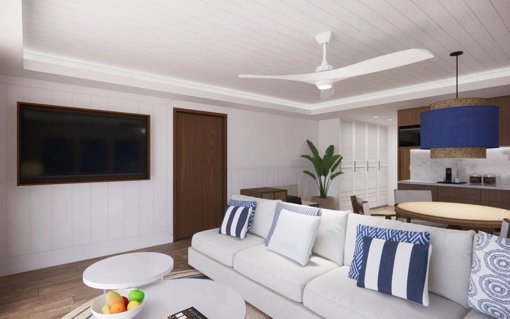 A modern living room with a white sofa, blue and white striped pillows, and a large flat-screen TV.