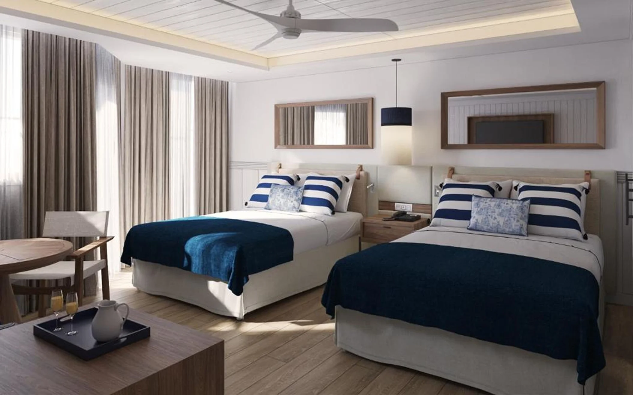 A well-lit hotel suite featuring two beds with blue and white striped bedding, and a sitting area.