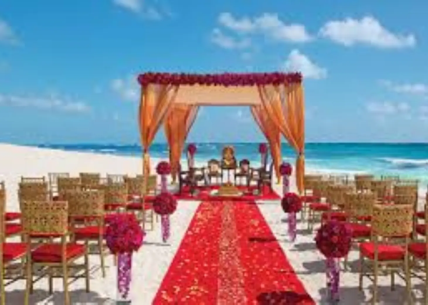 South Asian beach ceremony setup with a floral mandap at Secrets The Vine, Cancun