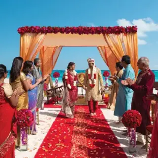 South Asian wedding ceremony under a floral mandap at Secrets The Vine, Cancun