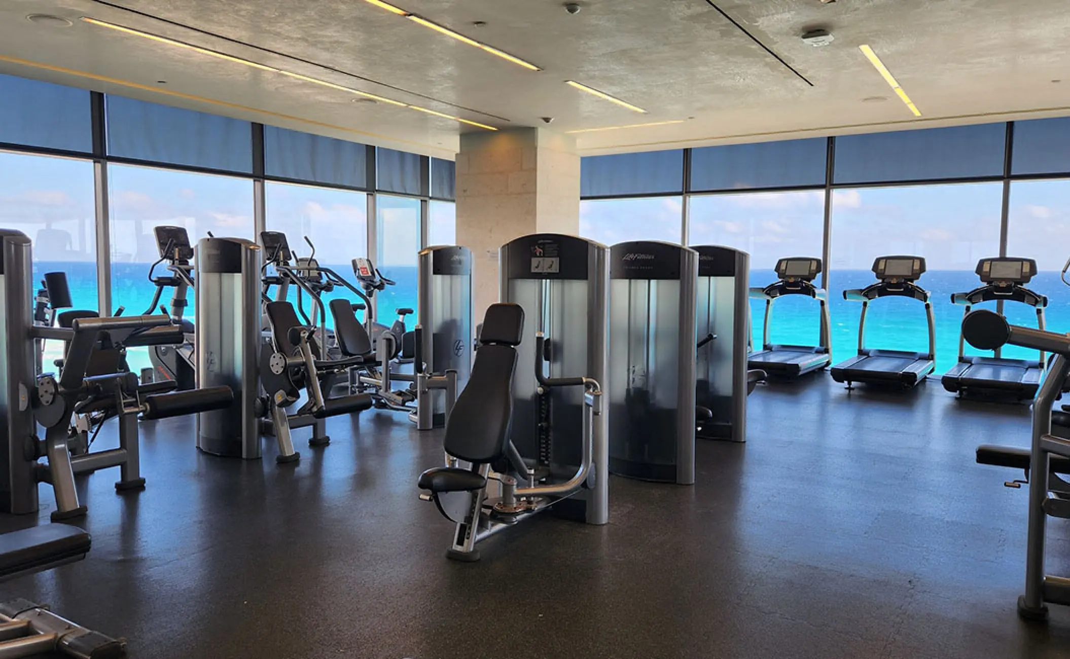 Fitness center with weight machines and treadmills facing the ocean at Secrets The Vine, Cancun