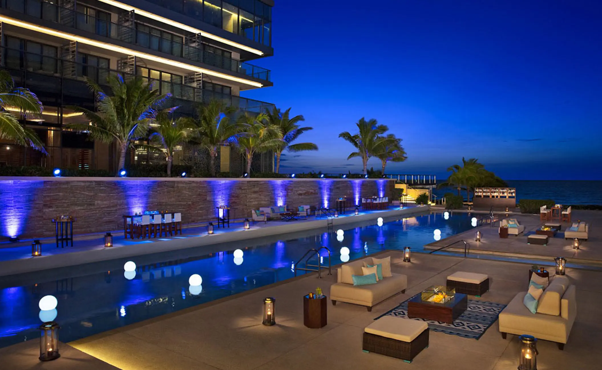 Illuminated poolside terrace and lounge seating at Secrets The Vine, Cancun