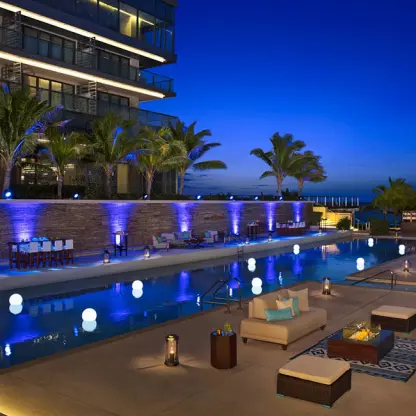 Illuminated poolside terrace and lounge seating at Secrets The Vine, Cancun