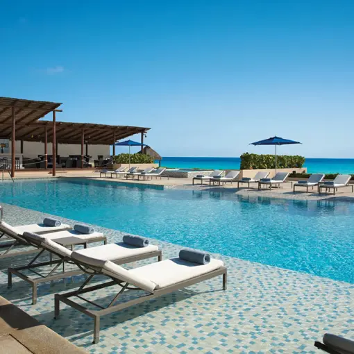 Secrets The Vine Cancun infinity pool with lounge chairs and ocean views, Cancun