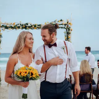 Bride and groom walking down the aisle at a beach ceremony at Secrets The Vine, Cancun