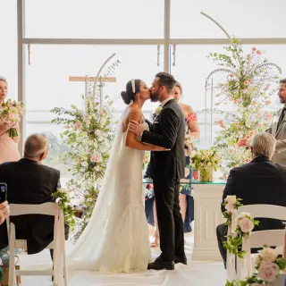 Bride and groom kissing during their wedding ceremony at Secrets The Vine, Cancun