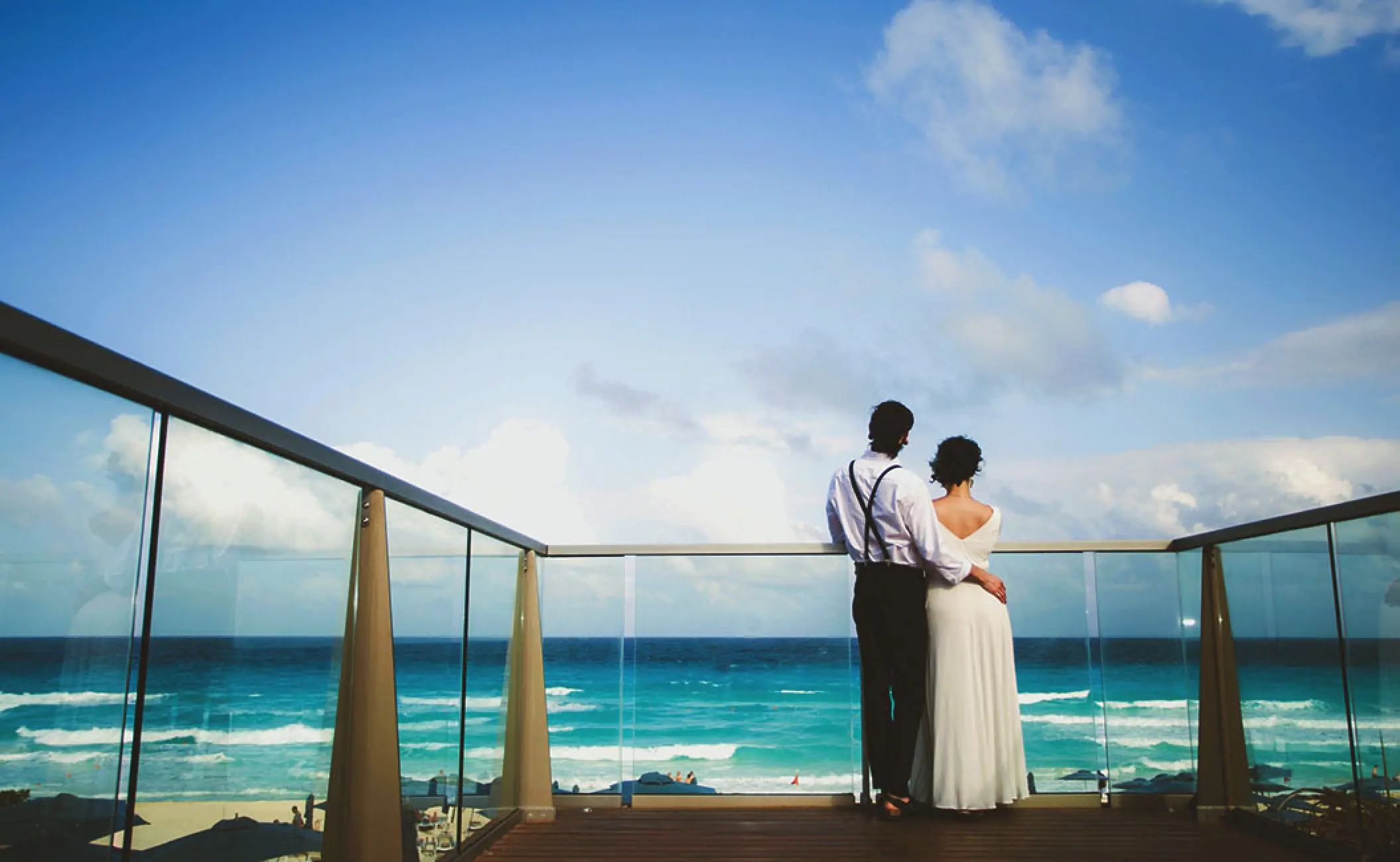 Couple looking out at the turquoise ocean from a balcony at Secrets The Vine, Cancun