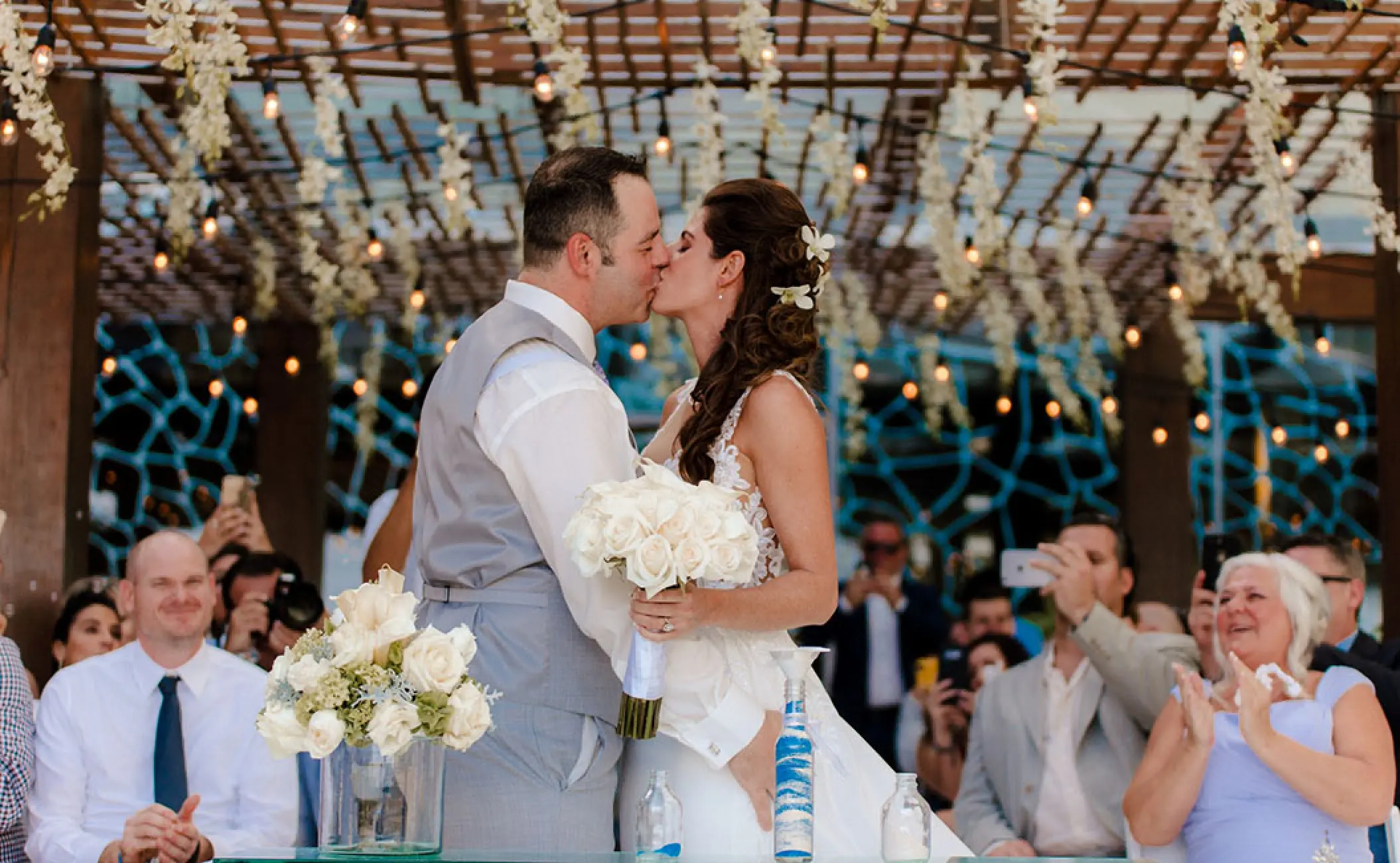The couple kissing at their wedding ceremony under a gazebo at Secrets The Vine, Cancun