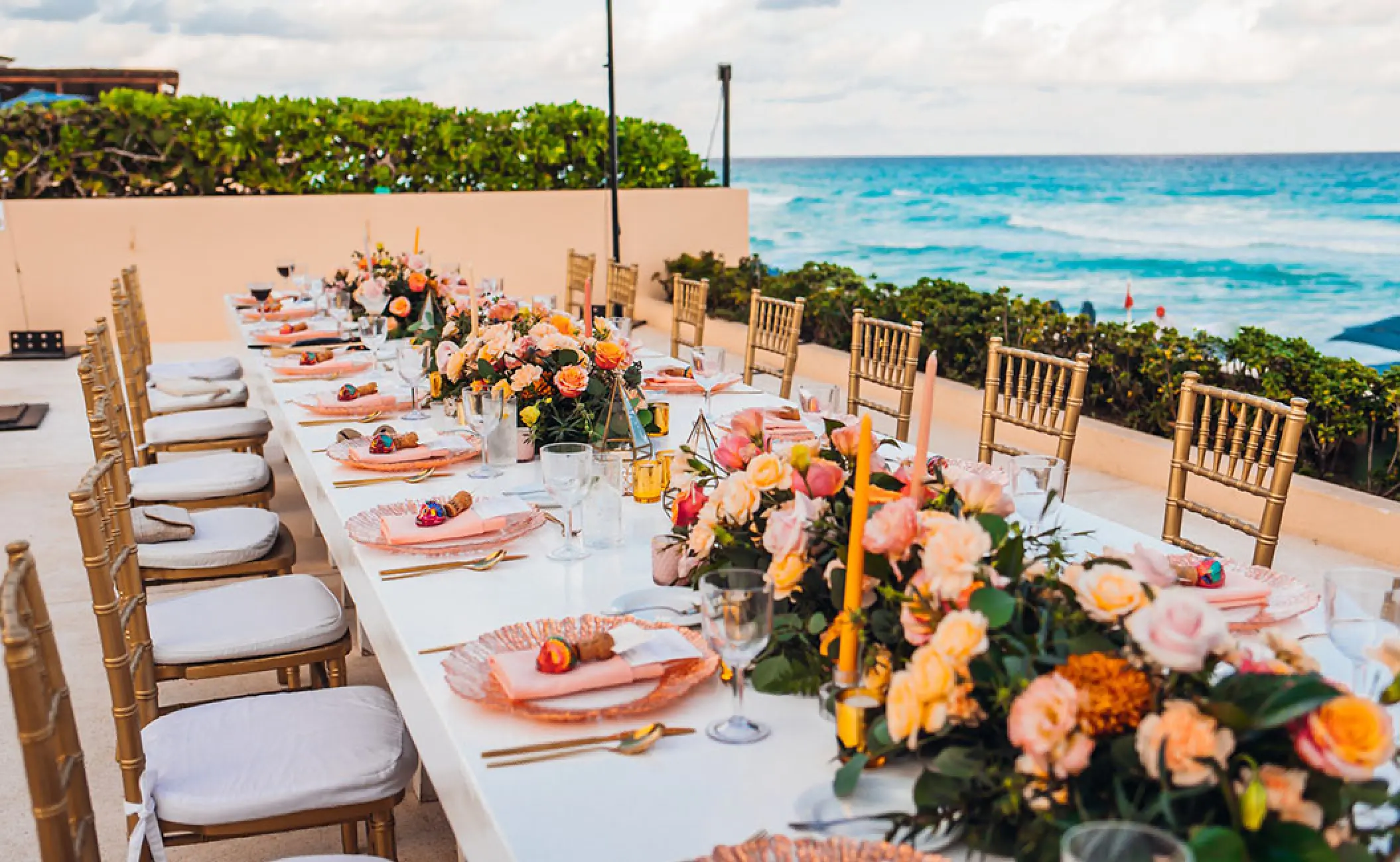 Terrace wedding reception with floral centerpieces overlooking the ocean at Secrets The Vine, Cancun