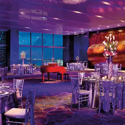 Indoor wedding reception with purple lighting and red piano at Secrets The Vine, Cancun