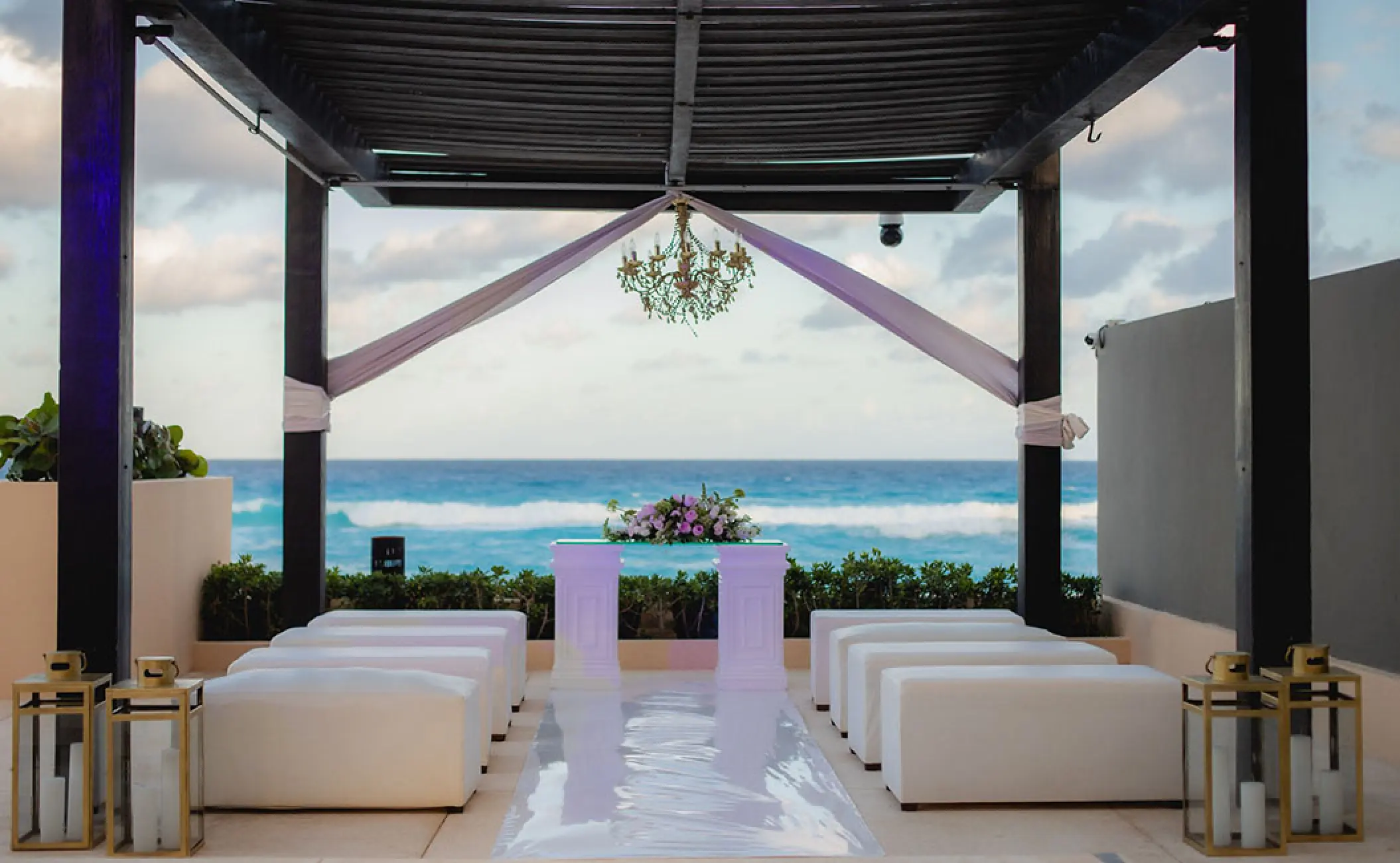 Terrace wedding ceremony under a dark wood gazebo at Secrets The Vine, Cancun
