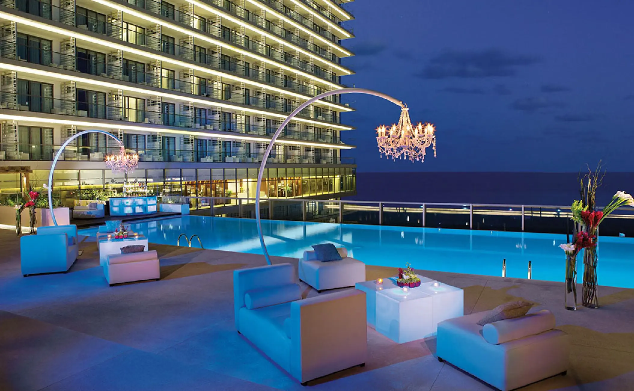 Preferred Club terrace reception venue with chandeliers and pool at Secrets The Vine, Cancun