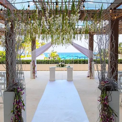 The Vine Lounge Terrace wedding ceremony setup with floral pergola at Secrets The Vine, Cancun