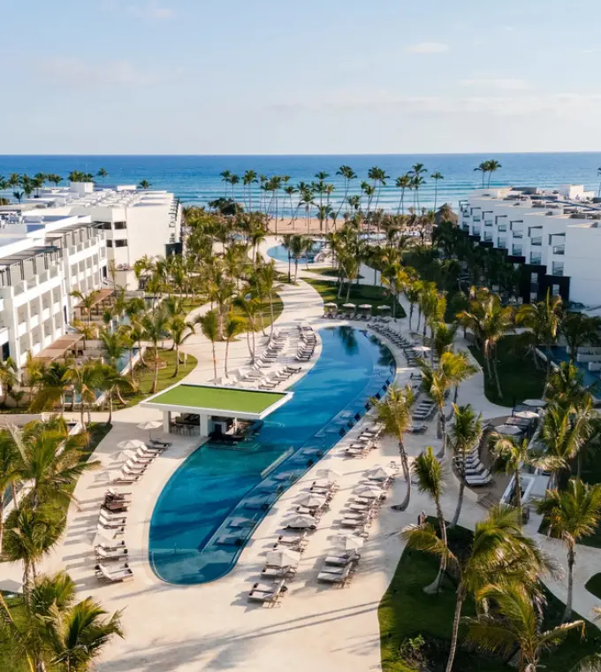Aerial view of Secrets Tides Punta Cana swimming pools and guest buildings leading to the beach