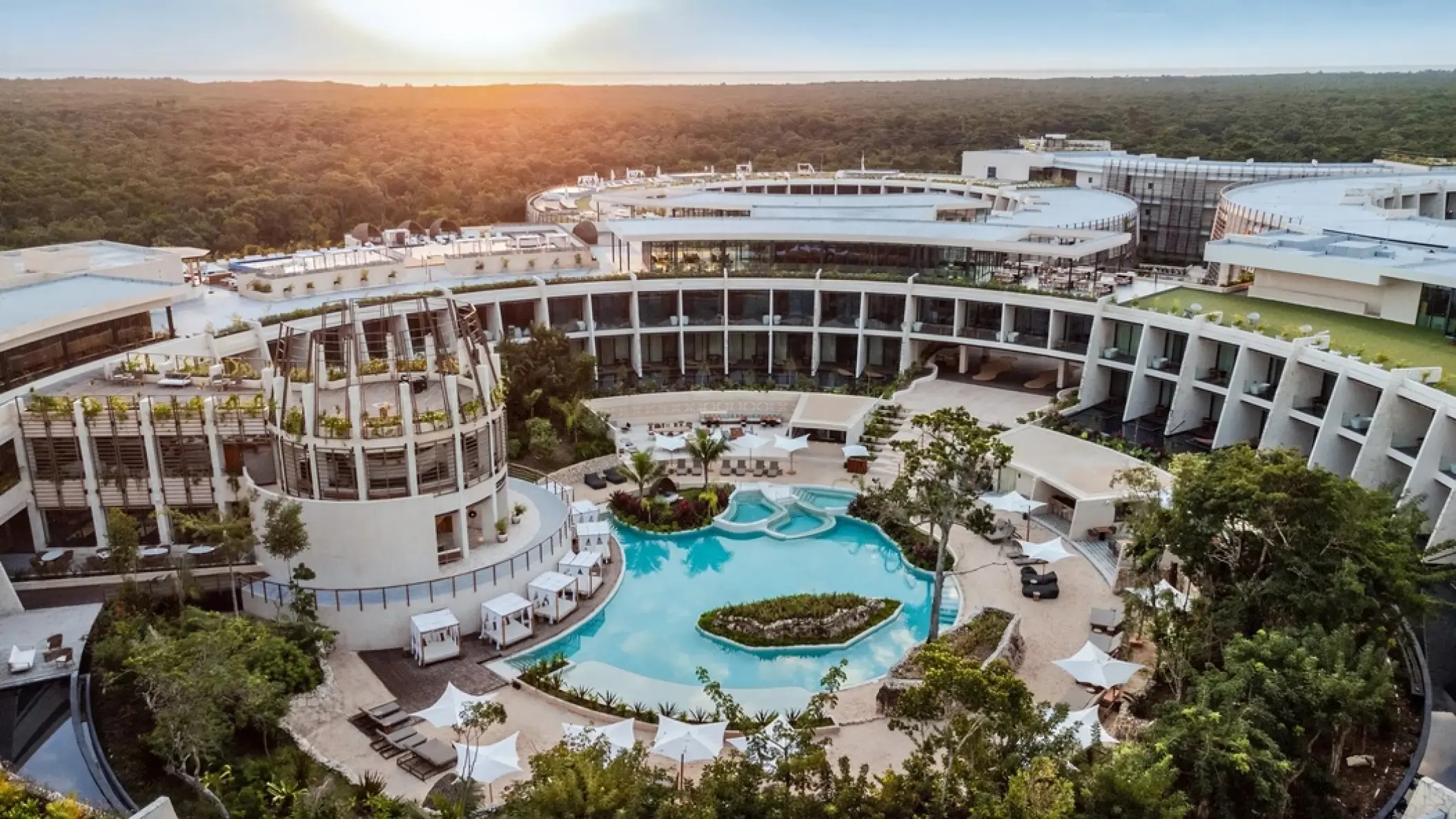 Aerial view of Secrets Tulum circular architecture and central pool at sunset, Tulum