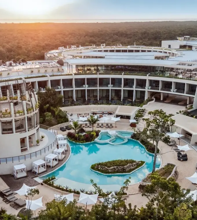 Aerial view of Secrets Tulum circular architecture and central pool at sunset, Tulum