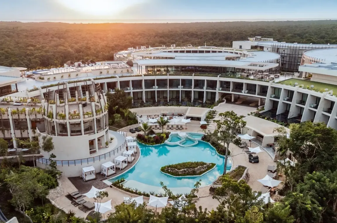 Aerial view of Secrets Tulum circular architecture and central pool at sunset, Tulum