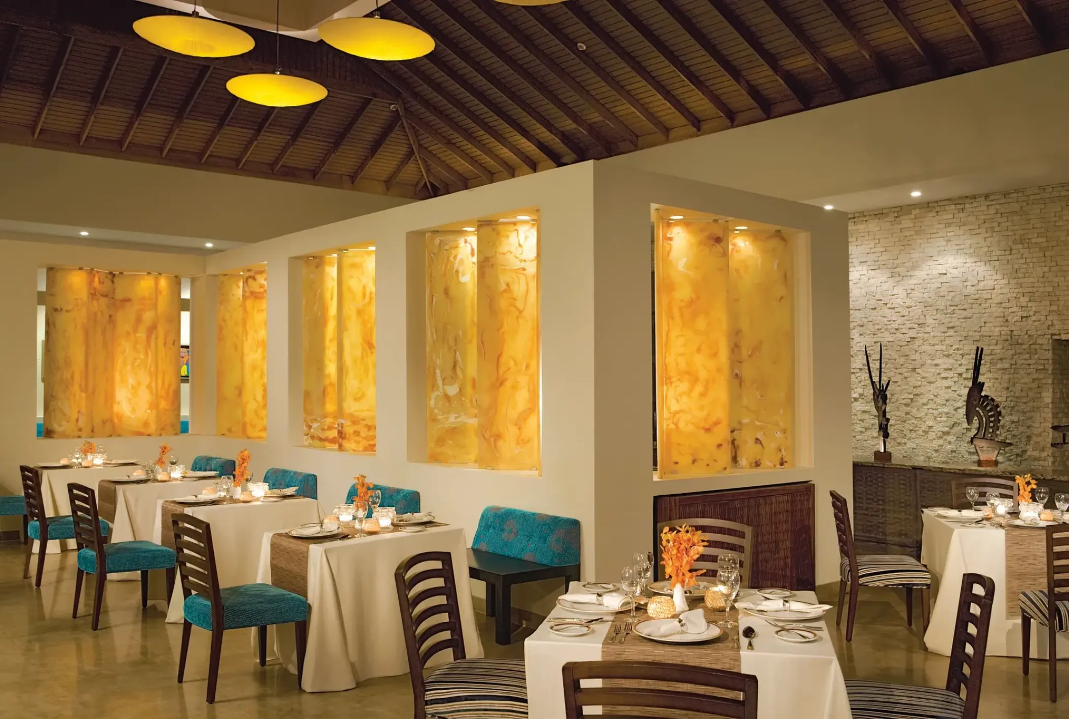 Blue Mountain restaurant dining area with lit wall niches at Secrets Wild Orchid, Montego Bay