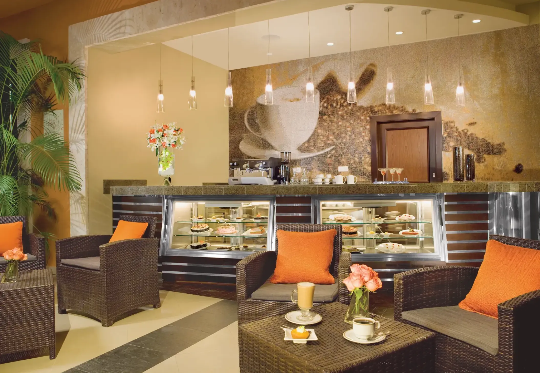 Coco Cafe coffee shop with wicker chairs and pastry display cases at Secrets Wild Orchid, Montego Bay