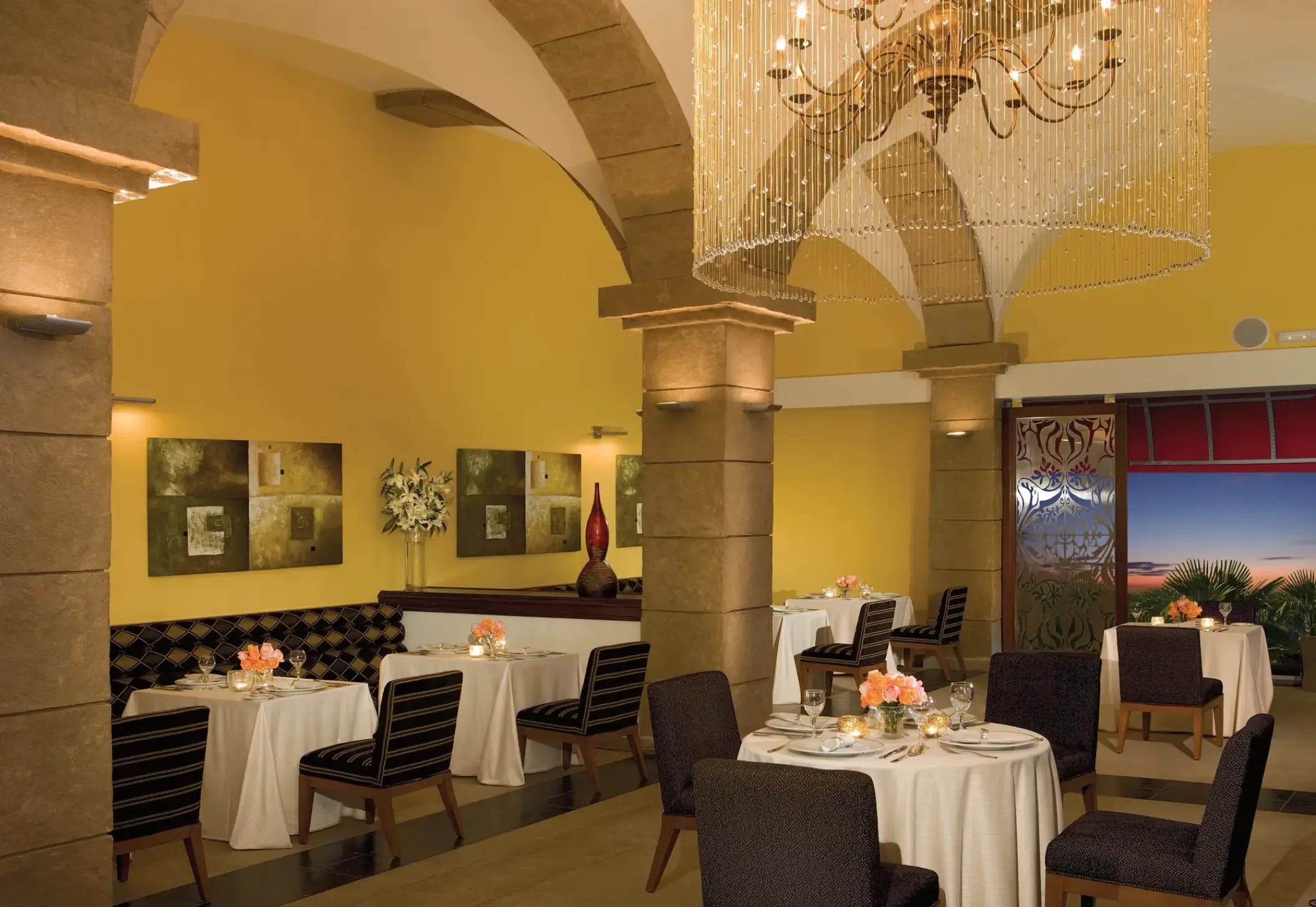 Portofino restaurant dining room with stone arches and crystal chandelier at Secrets St James, Montego Bay