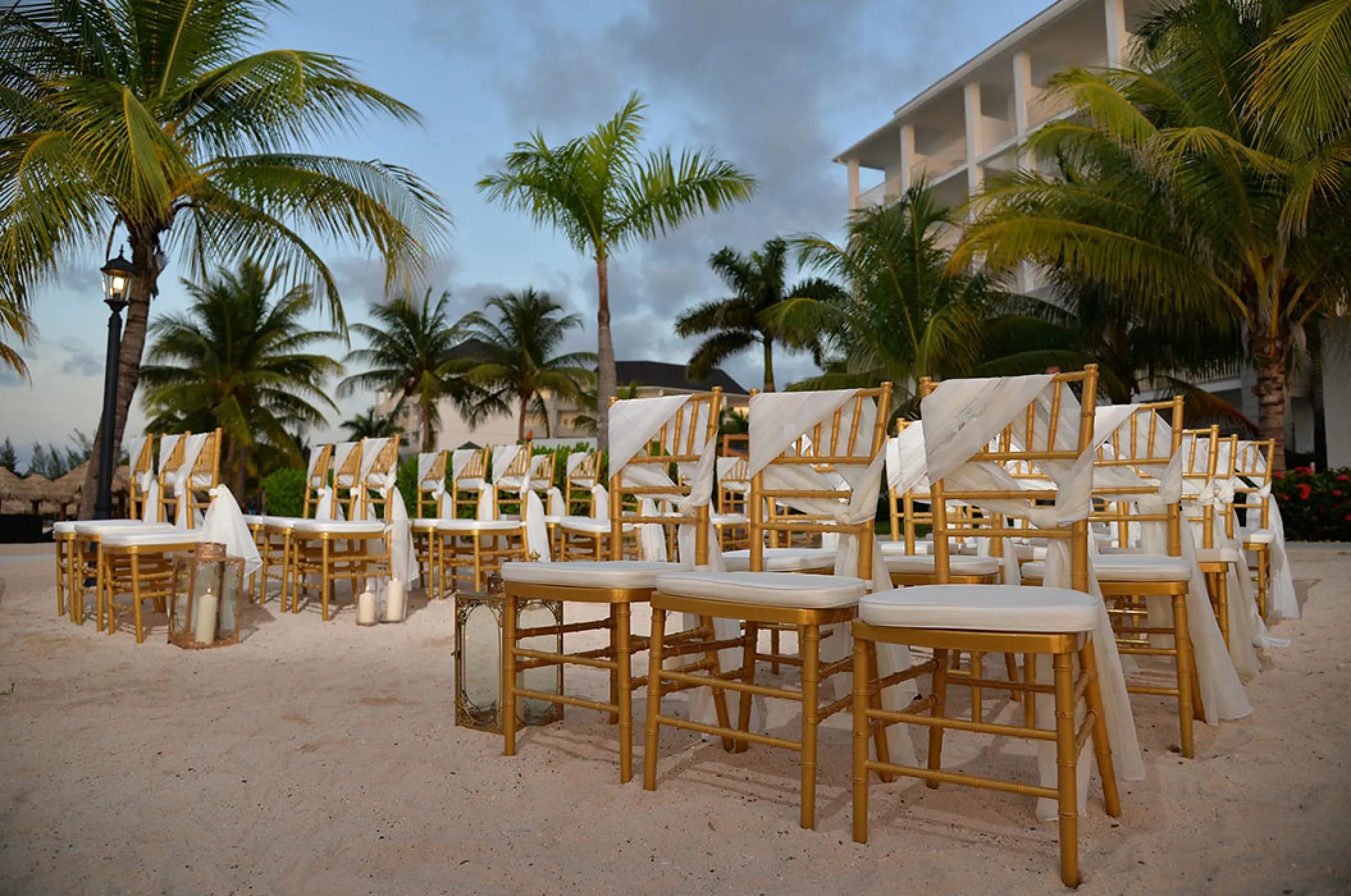 Barracuda Beach wedding ceremony setup with gold chairs at Secrets Wild Orchid, Montego Bay