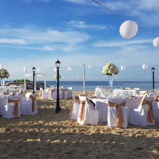 Beach wedding reception with white lanterns and floral centerpieces at Secrets St James, Montego Bay