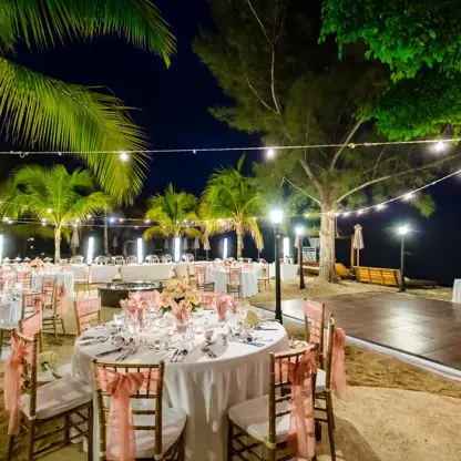 Beachfront wedding reception with string lights and dance floor at Secrets Wild Orchid, Montego Bay